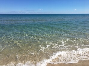 A beach with clear water and gentle waves.