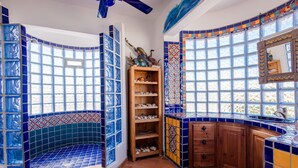 A bathroom with blue-tiled walls, a wooden vanity, and a large window. - Mariposa Azul 5 Bed 5 Bath By FMI Rentals (Puerto Peñasco Centro)