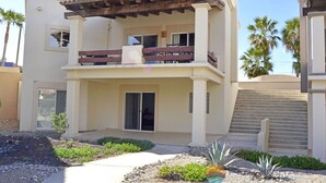 Une maison à deux étages avec un balcon, une terrasse et une allée.