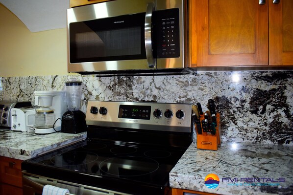 A kitchen with a stainless steel microwave, a coffee maker, a toaster, and a knife block. - Marina Pinacate B-403 Ocean View 2 Bed/ 2 Bath (Puerto Peñasco Centro)