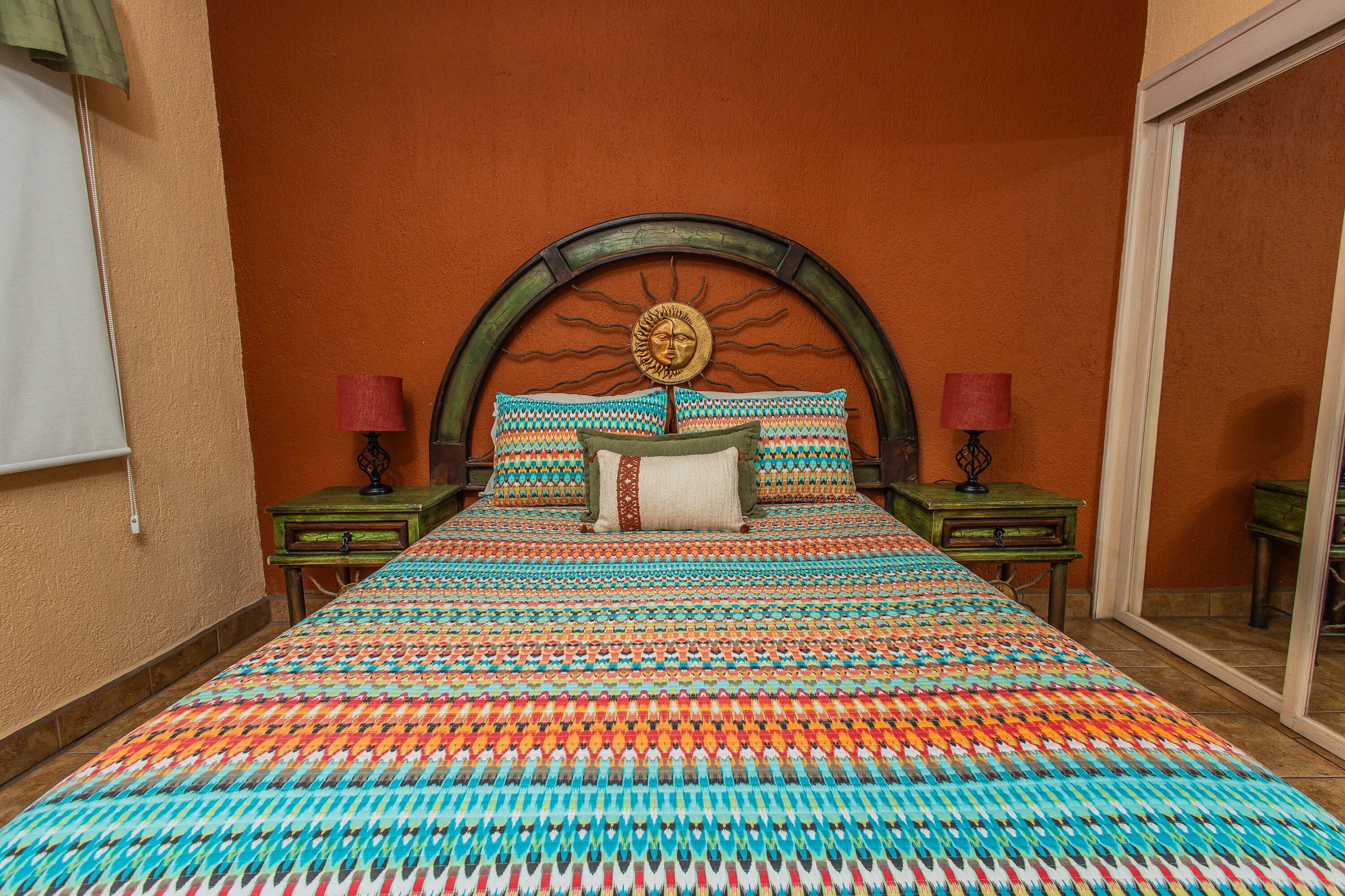 Una stanza con un letto grande, un pannello decorativo a caposonna e due comodini con lampade.