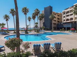 Relax by the pool surrounded by lush greenery and ocean views.