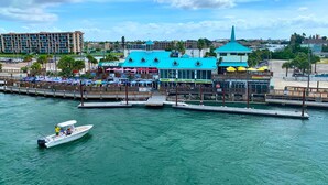 A waterfront restaurant with outdoor seating and a dock.