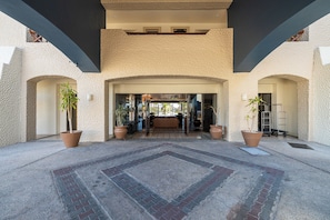 Enter a welcoming space with a modern design, framed by arches and lush greenery.