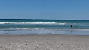 Ein Strand mit blauem Himmel und ruhiger Welle.