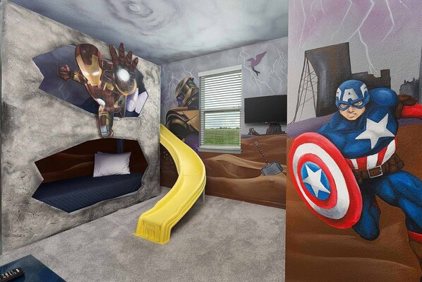 A bedroom with a bed, a yellow slide, and superhero-themed wall art.
