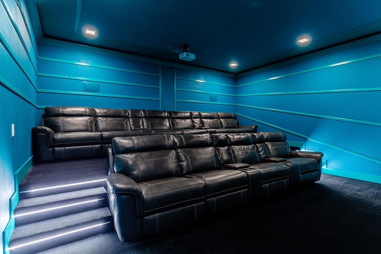 Ein Heimkino mit gestaffelten Sitzplätzen und einem großen Bildschirm.