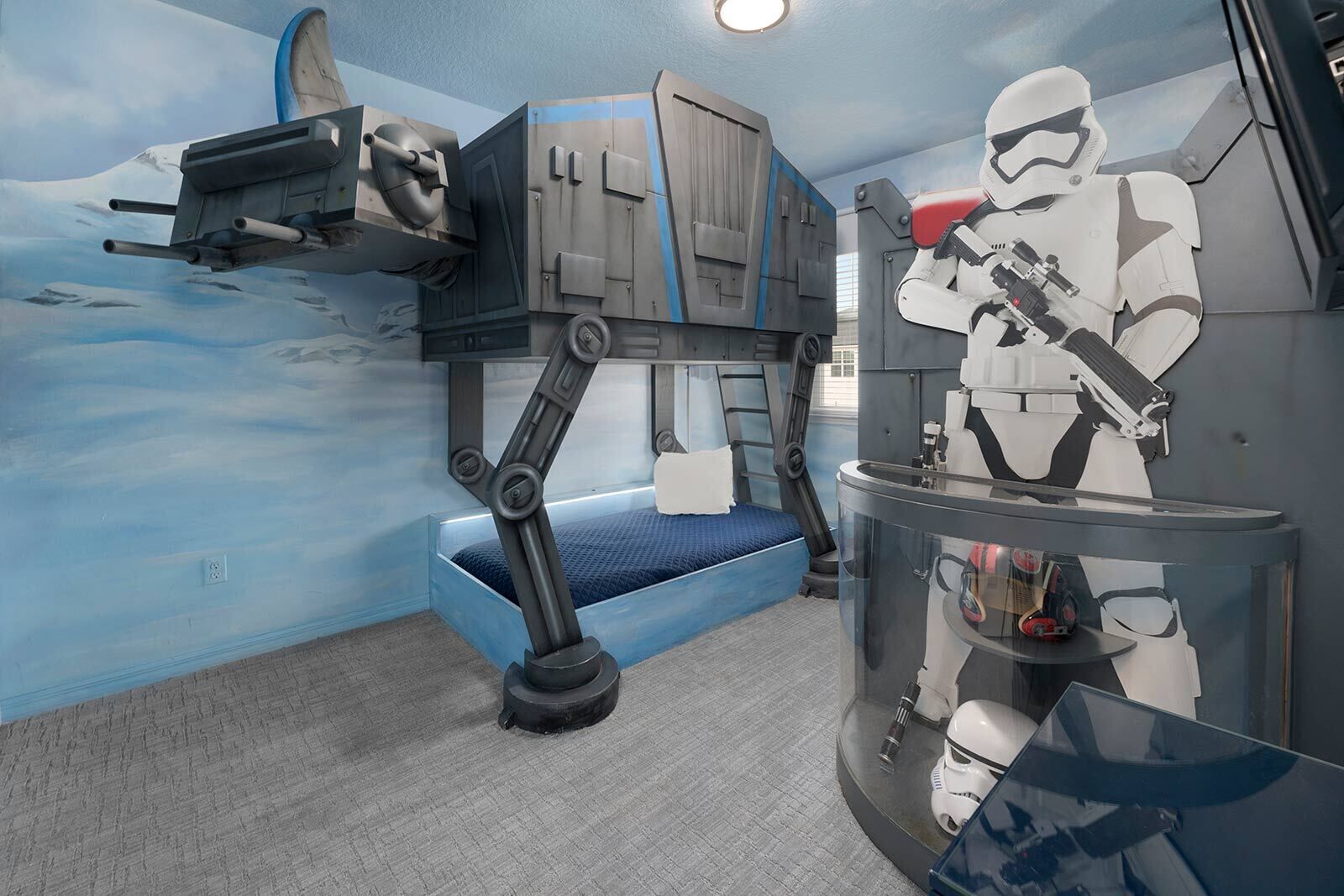 Een kamer met een stapelbed, een muurschildering met Star Wars-thema en een displaykast met een Stormtrooper figuur.