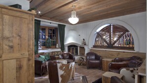 A rustic interior with wooden beams, leather furniture, and a brick floor. - Landhotel Vordergrub (Kitzbuhel)