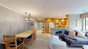 A modern living space with a dining area, kitchen, and seating area.
