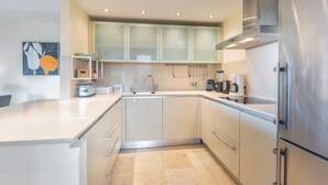 A modern kitchen with white cabinets, a stainless steel refrigerator, and a coffee maker. - Bahia - Beneharo 1.1 DELUXE SEA VIEW 2B (Arona)