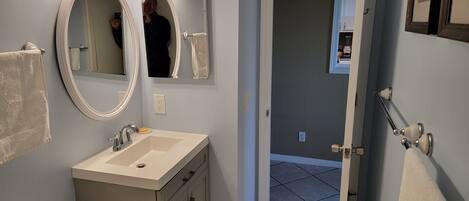 A bathroom with a vanity, sink, and two mirrors.