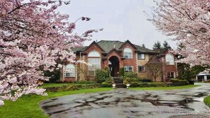 A two-story house with a brick facade, large windows, and a front entrance with steps. - Cedar Manor Bed and Breakfast (Pitt Meadows)
