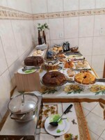 Una mesa de buffet con diversos alimentos y utensilios.