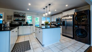 A modern kitchen with white cabinets, stainless steel appliances, and a central island. - 2027 NOW OPEN! UNION PIER HOME, PRIVATE ASSOCIATION BEACH ACCESS, HOT TUB! (Union Pier)