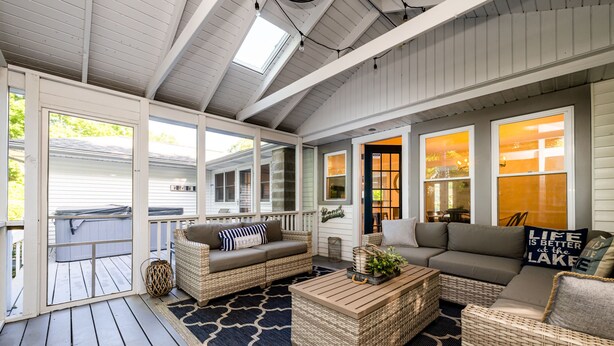 A covered porch with wicker furniture, a patterned rug, and a view of the backyard. - 2027 NOW OPEN! UNION PIER HOME, PRIVATE ASSOCIATION BEACH ACCESS, HOT TUB! (Union Pier)