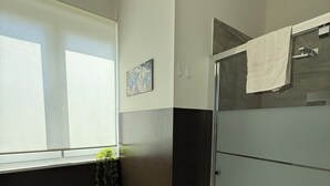 A modern bathroom with a toilet, sink, and shower. - Location10 (Palermo)
