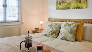 A neatly made bed with a tray of croissants, two mugs, and a coffee pot. - 1 bedroom accommodation in Findon, near Worthing (Findon, near Worthing)