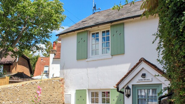 A quaint cottage with a stone wall, a small garden, and a sign reading "Manor Cottage." - 1 bedroom accommodation in Findon, near Worthing (Findon, near Worthing)