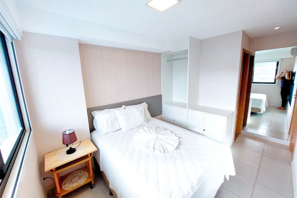 Ein Hotelzimmer mit Bett, Nachttisch und Spiegel.