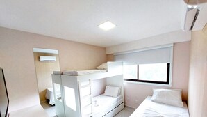 A bunk bed room with a window, a desk, and an air conditioning unit. - Flats no Cupe Beach Living (Ipojuca)