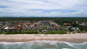 An aerial view of a resort with multiple buildings, a beach, and a pool area. - Flats no Cupe Beach Living (Ipojuca)