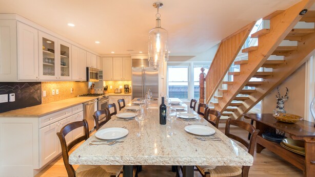 A spacious kitchen with a marble countertop, wooden chairs, and a built-in stove. - Christel - Peaceful West End Home, Downtown Telluride, Walk to Ski (Telluride)