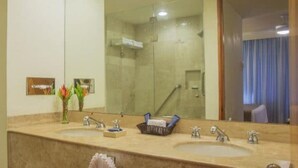Ein Badezimmer mit zwei Waschbecken, einem großen Spiegel und einer Duschkabine.