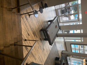 Relax in a spacious room with a pool table, comfortable seating, and large windows offering a view of the surrounding neighborhood.