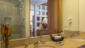 A bathroom with two sinks, a large mirror, and a shower area. - Club Regina Grand 2! (Marina Vallarta)