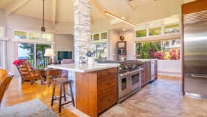 A spacious kitchen with a large island, built-in oven, and stainless steel appliances.