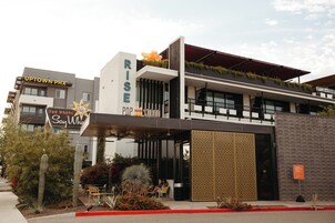 Un edificio moderno con un cartello che riporta 'UPTOWN PHX' e 'RISE POP'.