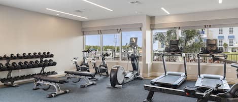 Un gimnasio con cintas de correr, elípticas y mancuernas.