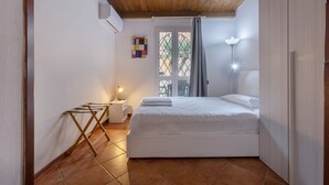 Un dormitorio con una cama, una mesita de noche, una lámpara, una ventana con cortinas y un techo de madera.