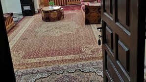 A living room with a sofa set, a coffee table, and a patterned rug. - Jerash Inn (Jerash)