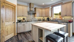 Una cocina moderna con armarios de madera, una isla central y un amplio ventanal.