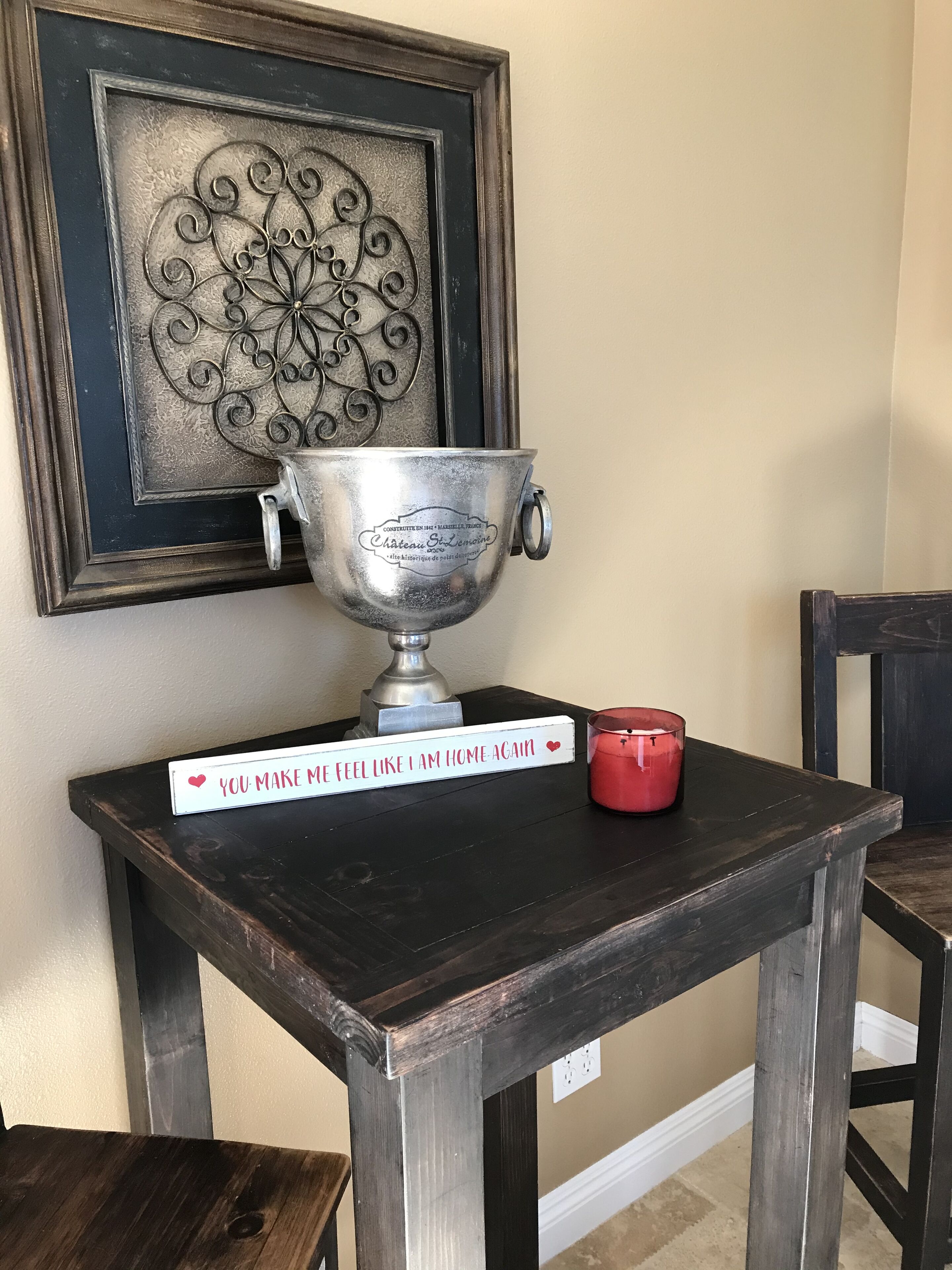 Eine Metallschale auf einem Holztisch mit einem Schild, auf dem steht: 'Du lässt mich wieder wie zu Hause fühlen.'