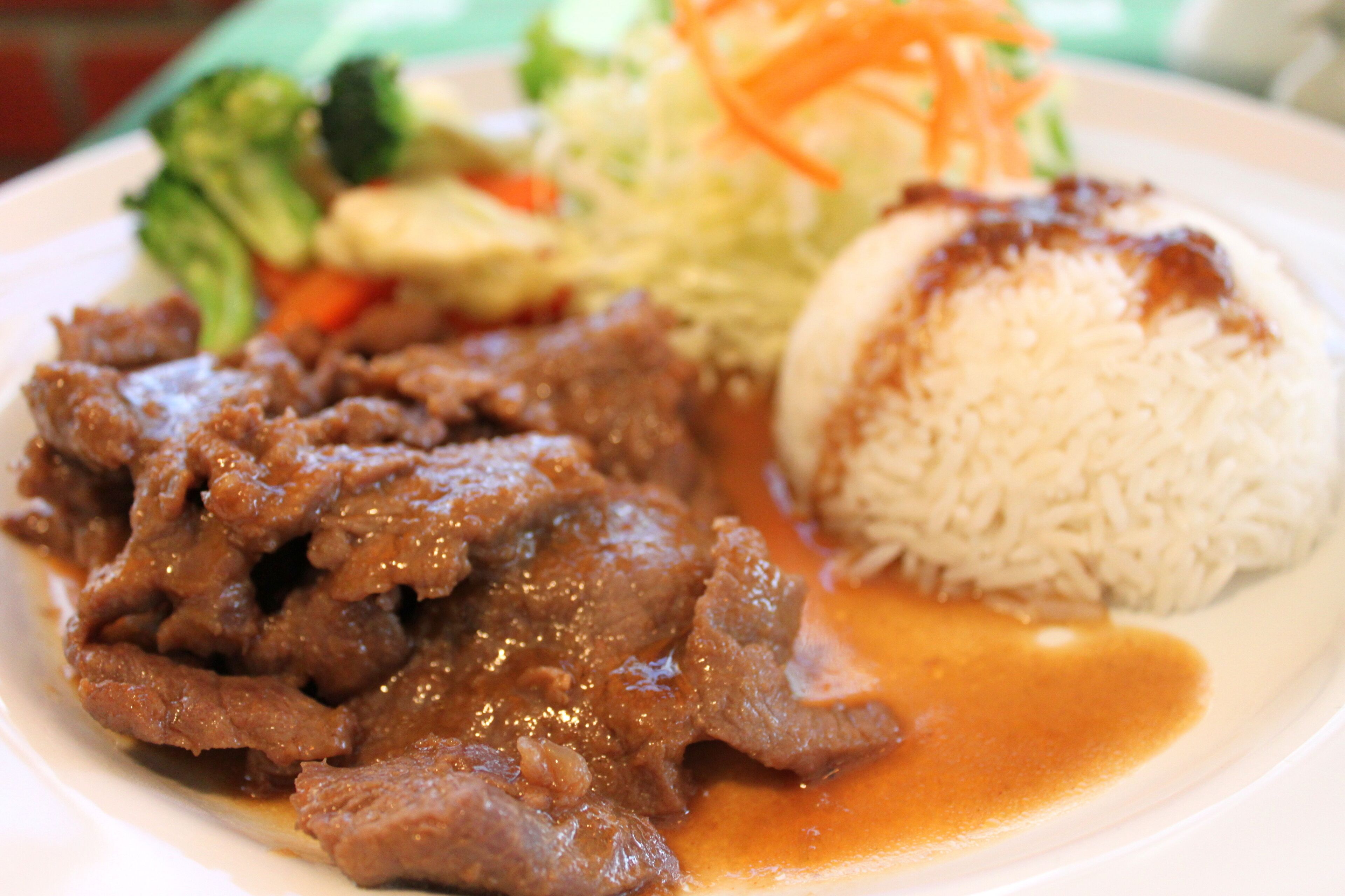 A plate with beef, rice, and vegetables.