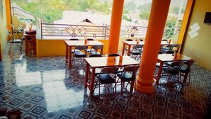 A restaurant with a tiled floor, wooden tables, and chairs. - Fifawind Hotel Komodo (Labuan Bajo)