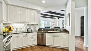 Enjoy cooking in this well-equipped kitchen with an oven, stainless steel appliances, and a large island with a sink.