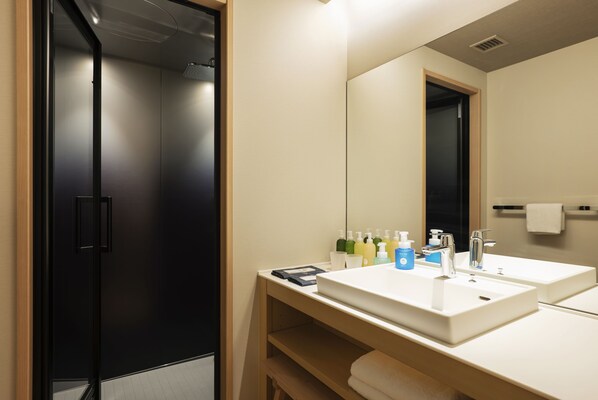 Un baño moderno con dos lavabos, un espejo grande y una zona de ducha.