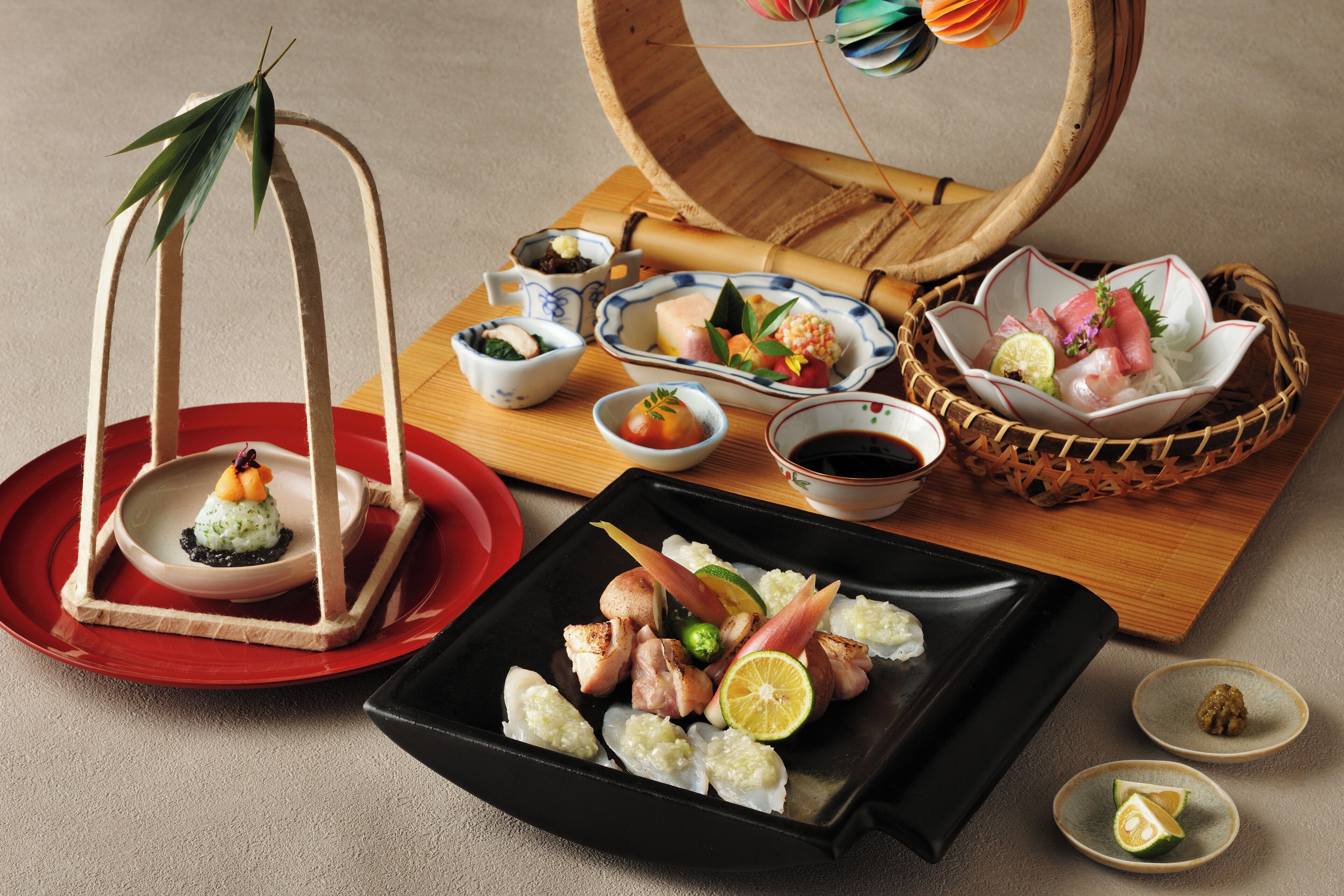 Diversos pratos japoneses, incluindo sushi, sashimi e uma planta decorativa.