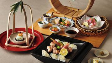 Diversos pratos japoneses, incluindo sushi, sashimi e uma planta decorativa.