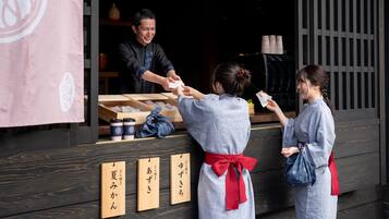 Una estructura de madera con mostrador y paneles de madera con texto japonés.