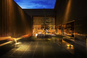 A modern spa area with a wooden bench, a small water feature, and a view of a landscaped garden. - Hoshino Resorts KAI Nagato (Nagato)