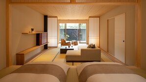 Ein traditioneller japanischer Raum mit Tatami-Böden, einer niedrigen Holzbalkendecke und Schiebetüren.
