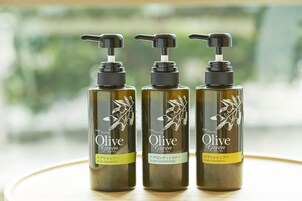 Tres botellas de champú y acondicionador de la serie Verde Oliva sobre una mesa.