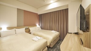 Ein Hotelzimmer mit zwei Betten, einem Fernseher und einem Holztisch.