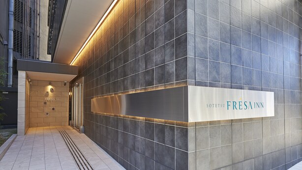 Eine moderne Gebäudefassade mit einem Schild für 'Sotetsu FRESA INN'.