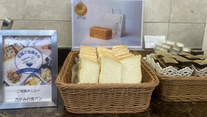 Zona de buffet con pan, un cartel que indica 'Japan Food Selection' y una presentación de comidas locales.
